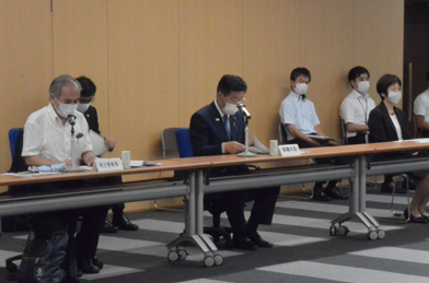 写真:3人が間隔をあけて着席している。