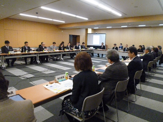 写真:机が大きくコの字型に配置され、30人弱が座っている。