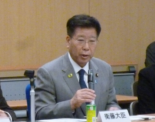 写真:着席し、マイクを手に発言している衛藤大臣。