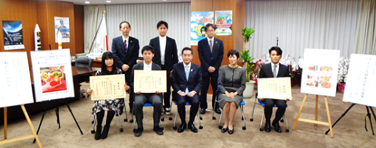 写真:井上内閣府特命担当大臣と伊藤消費者庁長官を中心に、賞状を手にした受賞者と並んで座っている。