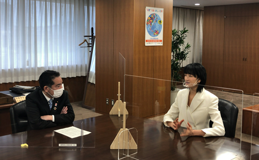 写真:会議机の上に透明なパーテーションを挟み、懇談する井上大臣と富永愛氏