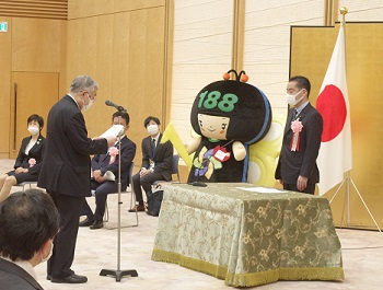 写真:受賞者代表と井上大臣が向かい合っている。受賞者代表が、井上大臣に向け謝辞を読みあげている。