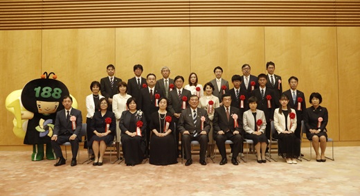 座っている石破総理大臣と伊東大臣を中心に、複数の受賞者が並んでいる。