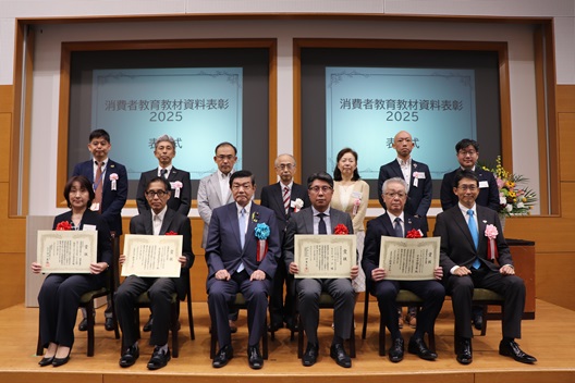 座っている伊東大臣を中心に、複数の受賞者が並んでいる。