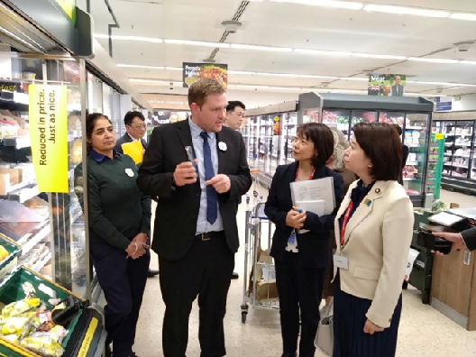 写真:スーパーの売り場で説明を受ける大臣