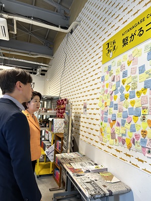 写真:メッセージボードの前に立つ自見大臣