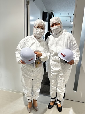 写真:自見大臣と伊藤倉敷市長が、食品衛生用の白衣を着てマスクをし、ヘルメットを手に持っている。