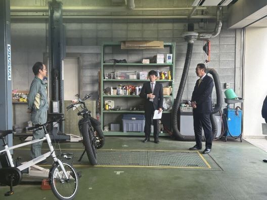 写真:違法電動自転車を目の前に、説明を受ける様子