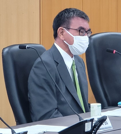 写真:白いマスクをし、会議の席についている河野大臣