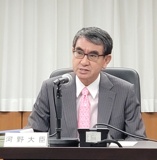 写真:スタンドマイクの前に座り発言する大臣。机の上には、「河野大臣」の札が置かれている。