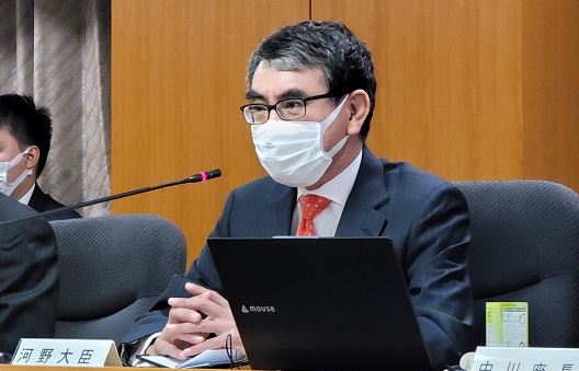 写真:スタンドマイクの前に座り発言する大臣。机の上には、「河野大臣」の札が置かれている。