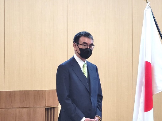 写真:祝辞を述べる河野大臣。大臣の横には国旗が立てられている