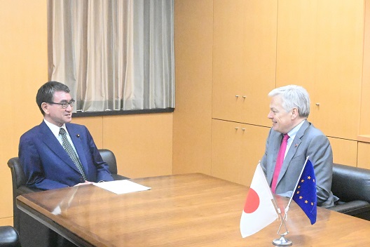 写真:左側に河野大臣、右側にレンデルス欧州委員が、向かい合って座っている。二人の手前、机の上には欧州旗と日本国旗が飾ってある。