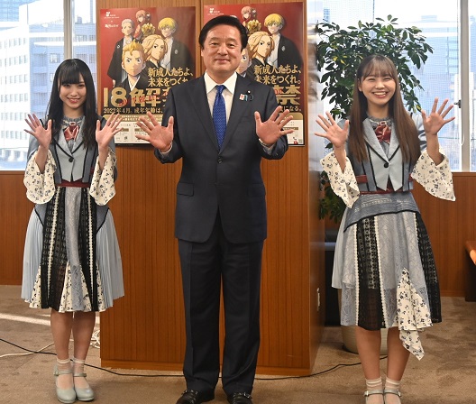 写真:若宮大臣を中心に、写真左側に梅山さん、写真右に、本郷さんが並んでいる。両手を広げるポーズを取り、3人の後ろには、18歳成人の啓発ポスターが貼ってある。