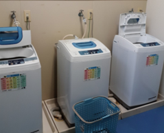 Photo: Three washing machines are lined up, with magnets with a quick laundry instructions chart attached to the front.