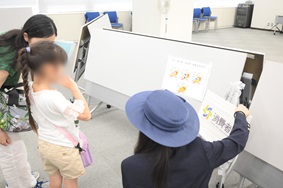 写真:参加者である子どもたちが、手にクリップボードを持ち、回答を記入したり考えたりしている様子