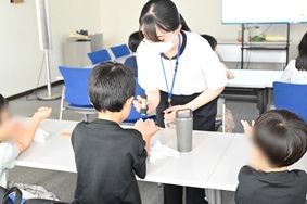 写真:子どもたちに実験を体験してもらっている様子