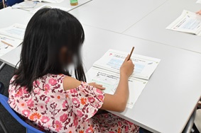 写真:クイズの用紙に書き込みをしている子ども