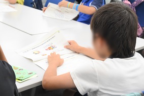 写真:クイズの用紙の説明を読んでいる子ども