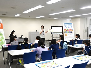 写真:参加者である子どもたちに、講師がモニターで動画を見せながら説明している様子