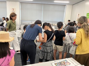 写真:参加者である子どもたちが、手にクリップボードを持ち、回答を記入したり考えたりしている様子