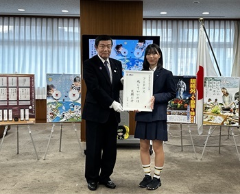 写真:伊東大臣と受賞者が、受賞作品の川柳の書かれたパネルを掲げ持っている