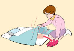 画像:湯たんぽを布団の中にいれている女性のイラスト