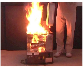 写真:石油ストーブのタンクから漏れた灯油に火が付き、ストーブが燃え上がっている