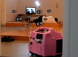 写真:テレビが着いてる部屋。倒れている人物の後ろで、発電機から一酸化炭素が出ているイメージ。